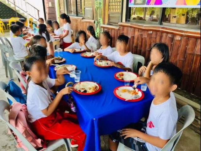 Children eating together during an Ako Ang Saklay feeding program; faces are blurred for privacy